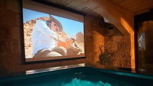 Zona de piscina con una pantalla grande que muestra un paisaje desértico.
