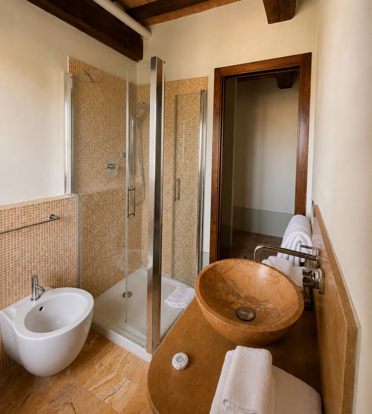 Un baño con ducha de vidrio, un bidet blanco y un lavamanos de madera.
