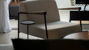 Ein modernes Zimmer mit großem Fenster, einer Couch, einem kleinen Tisch und einem Fernseher.