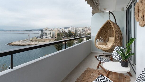 Ein Balkon mit einer Hängematte, einem kleinen Tisch und einem Blumentopf.