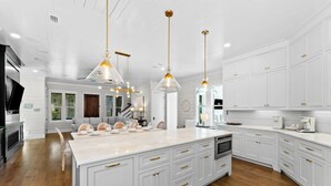 A modern kitchen with white cabinetry, a large island, and pendant lighting. - 🌴Almost Heaven • Gulf View Luxury with Private Heated Pool & Deeded Beach Access (Santa Rosa Beach)
