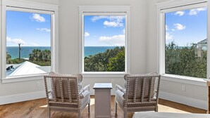 A room with three large windows offering ocean views, two upholstered chairs, and a small table. - 🌴Almost Heaven • Gulf View Luxury with Private Heated Pool & Deeded Beach Access (Santa Rosa Beach)