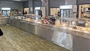 Een buffetruimte met roestvrijstalen toonbanken, diverse gerechten en een schoon, modern interieur.