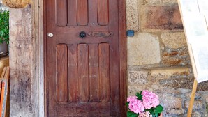 A wooden door with a lantern above it, set in a stone building. - Guest House Saint Yves (Dinan)