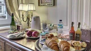 A breakfast table with croissants, apples, and a bottle of milk. - Guest House Saint Yves (Dinan)
