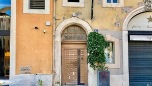 Ein Gebäude mit einer Holztür, einem kleinen Fenster und einem Schild darüber.