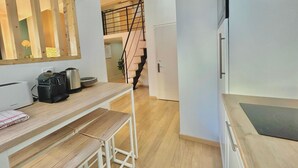 Eine kleine Küche mit einer Holzauskładung, einem Spülbecken und einer Treppe, die zu einer oberen Ebene führt.