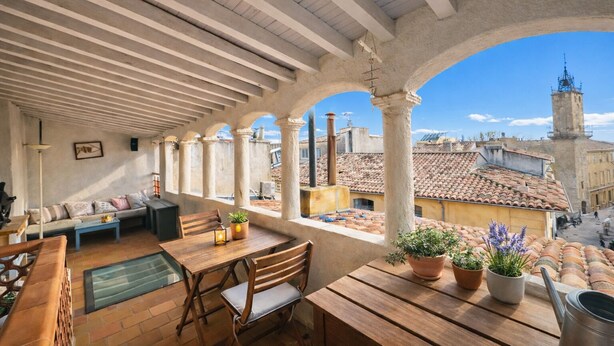 A covered patio with wooden furniture, potted plants, and a view of the cityscape. - Toit Vieil - Terrace with stunning view over Aix rooftops (Aix-en-Provence)