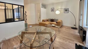 Ein modernes Wohnzimmer mit einem Glastisch, einer Couch und einer Stehlampe.