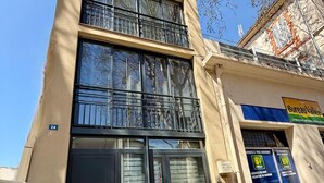 A two-story building with a ground-floor entrance, a visible mailbox, and a sign for 'Bureau Vallée'. - L'Amandier - Lovely New 2-Bedroom apt in Aix City Center (Aix-en-Provence)
