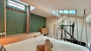 A bedroom with a large bed, a wooden dresser, a staircase with rope railings, and a green wall. - La Petite Lucarne - Vieux Port, Center Marseille/Panier (Marseille)