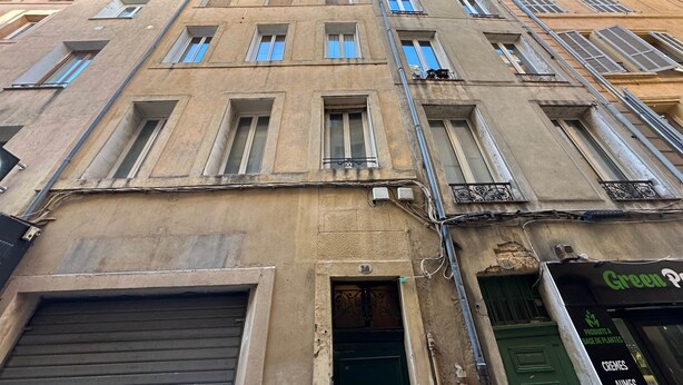 A multi-story building with a green door and a sign for 'Green Planet'. - Chez Florence - Spacious 1BR in Historic City Center (Aix-en-Provence)
