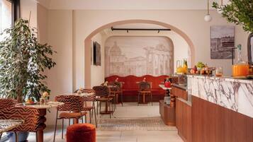 A restaurant with a marble counter, red upholstered seating, and a mural of ancient architecture.