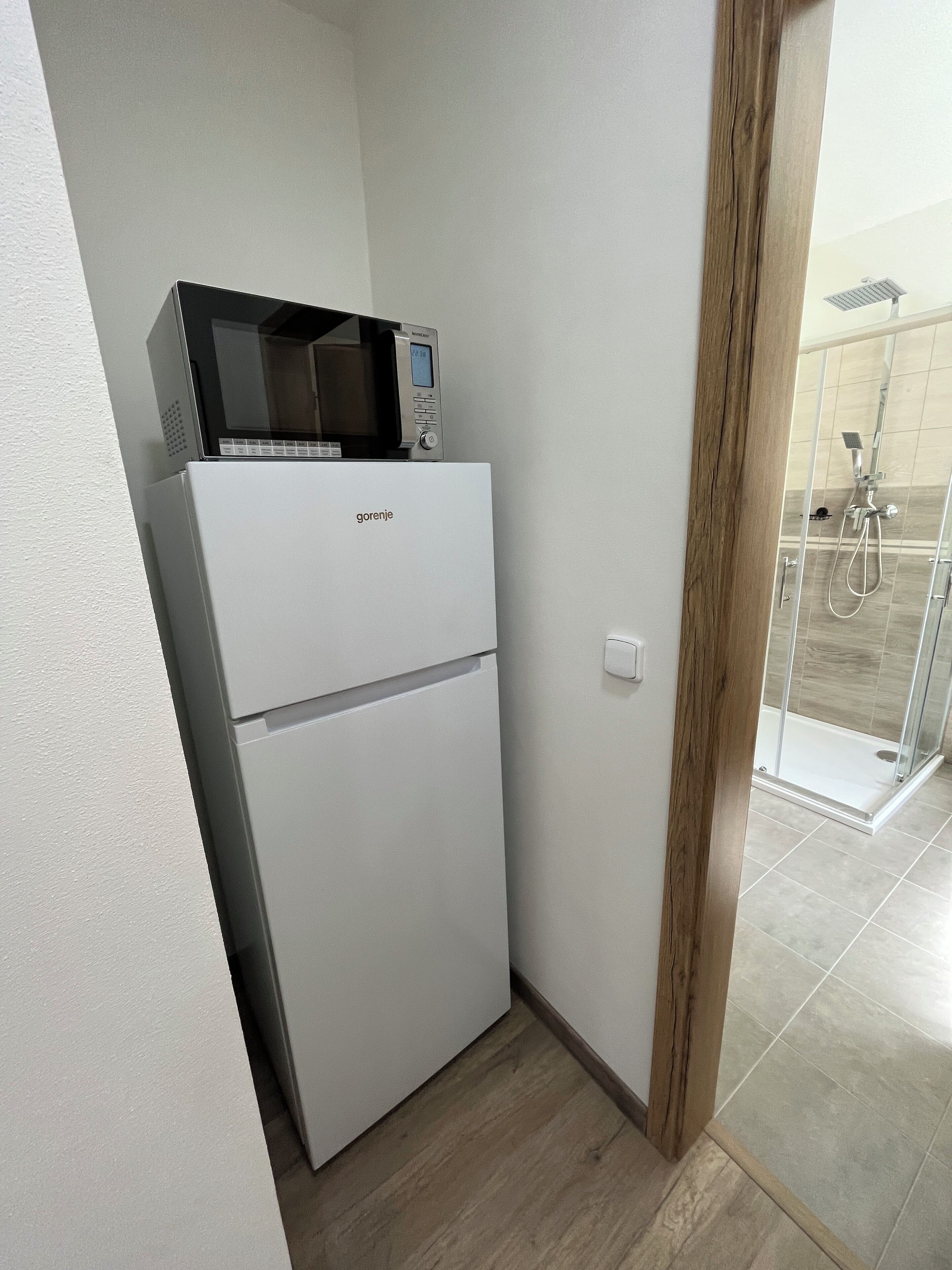 Una cocina compacta con un refrigerador blanco, un microondas y un horno pequeño.