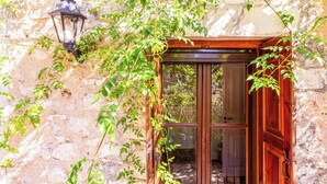 A stone building with a wooden door and a lantern. - Stone Cottage - Two Bedroom Villa, Sleeps 4 (Nisaki)