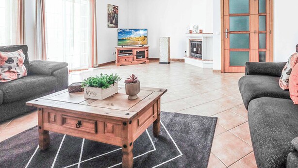 A living room with a wooden coffee table, two grey sofas, a television, and a fireplace. - Villa Ash - Four Bedroom Villa, Sleeps 8 (Alcantarilha)