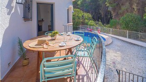 A patio with a round table, chairs, and a potted plant. - Villa Abeto - Two Bedroom Villa, Sleeps 4 (El Tosalet)