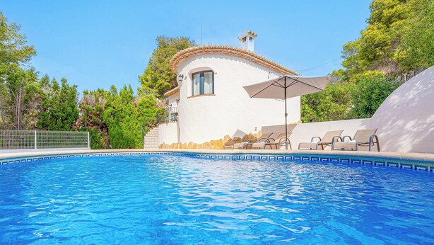 A swimming pool with lounge chairs and a white building with a tiled roof. - Villa Abeto - Two Bedroom Villa, Sleeps 4 (El Tosalet)