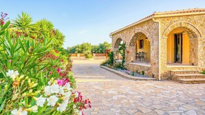 A stone building with arched doorways and a patio area.