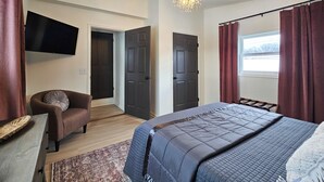 A bedroom with a bed, a chair, a TV, and a window with curtains. - NEW! Hot Tub, Firepit & Game System Near Hershey - Walk To Lake & Fishing! (Lebanon)