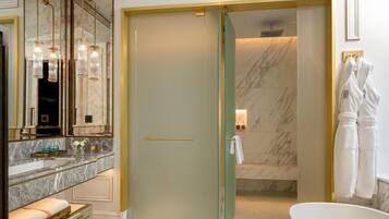 Une salle de bain moderne avec un grand miroir, une porte de douche en verre et une baignoire.