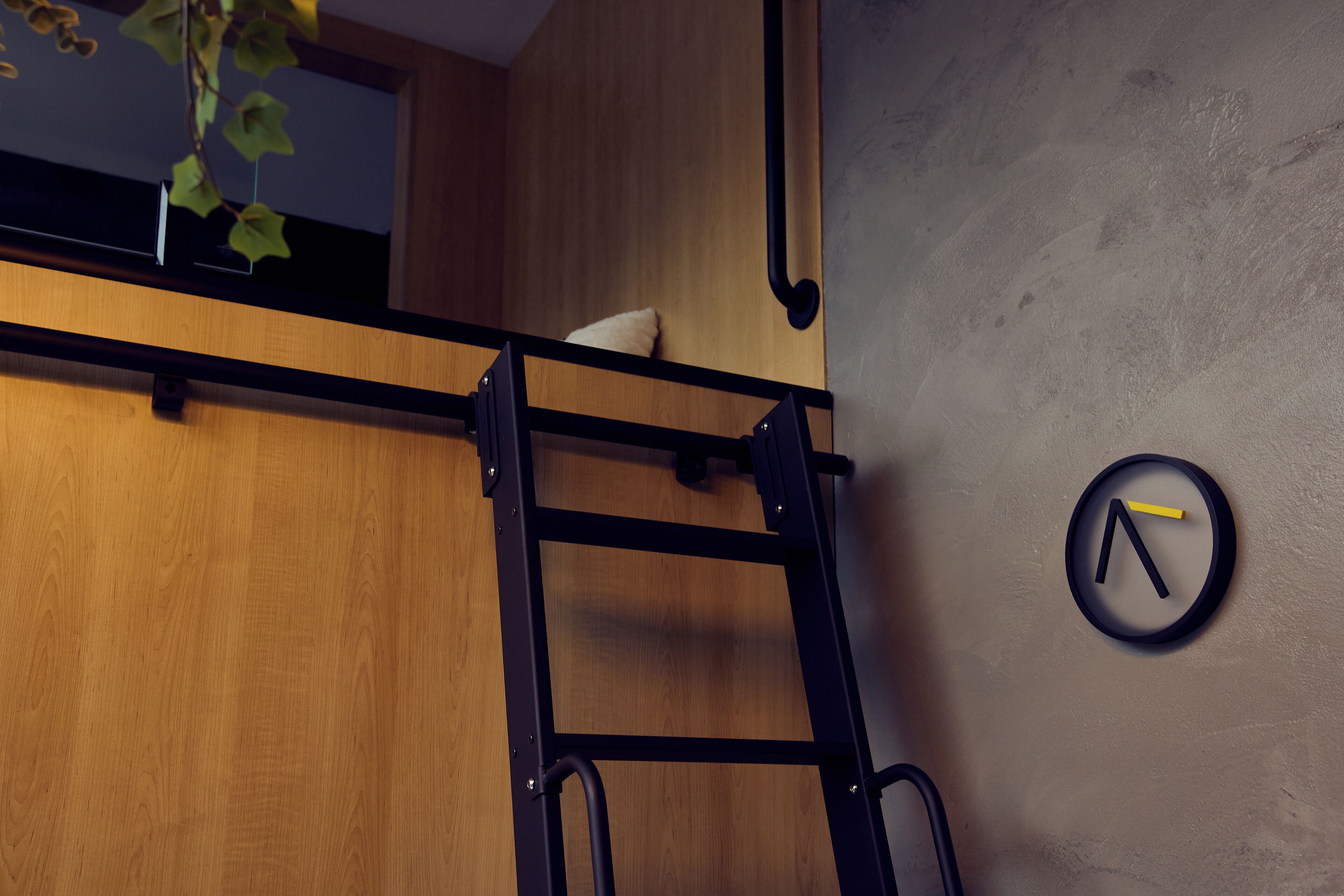 A bunk bed with a pull-up bar, a clock, and a wooden wall.