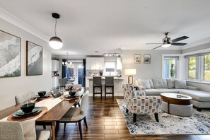 Una sala moderna con comedor, un sofá y un ventilador de techo.