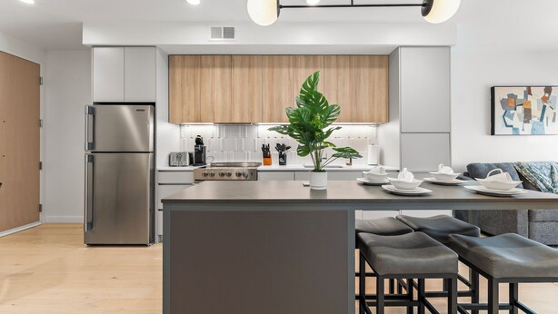 Una cocina moderna con una isla central, electrodomésticos de acero inoxidable y un armario de madera.