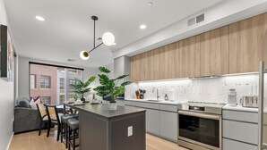 Een moderne keuken met een centraal eiland, inbouwapparatuur en uitzicht op de stad.