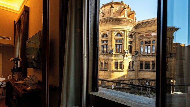 A room with a large window overlooking a historic building with classical architecture. - Palazzo Doni by Florence Art Apartments (Florence)