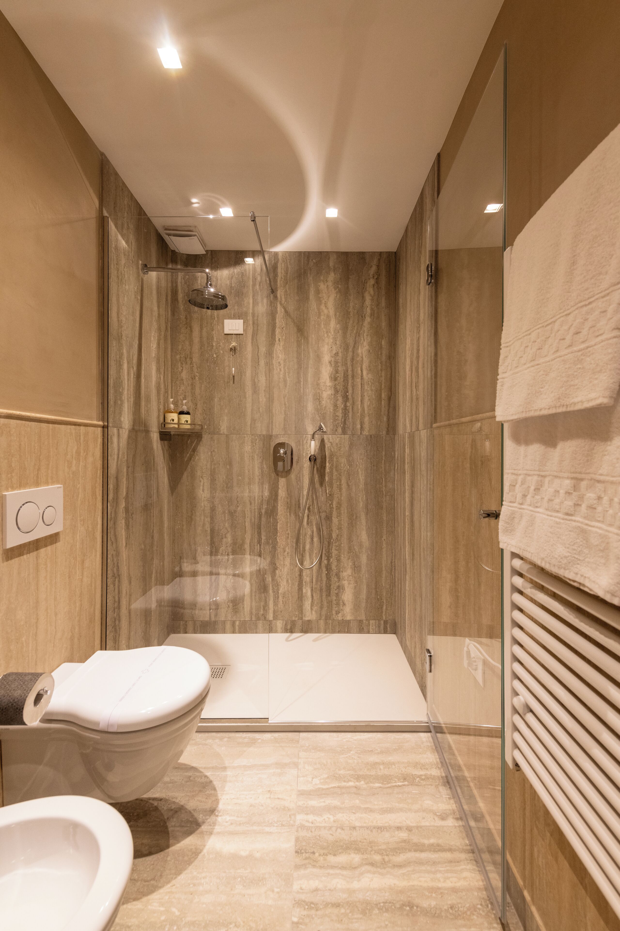 Un bagno moderno con doccia vetrata, un water e un bidet.