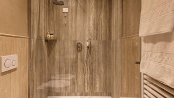 Un bagno moderno con doccia vetrata, un water e un bidet.