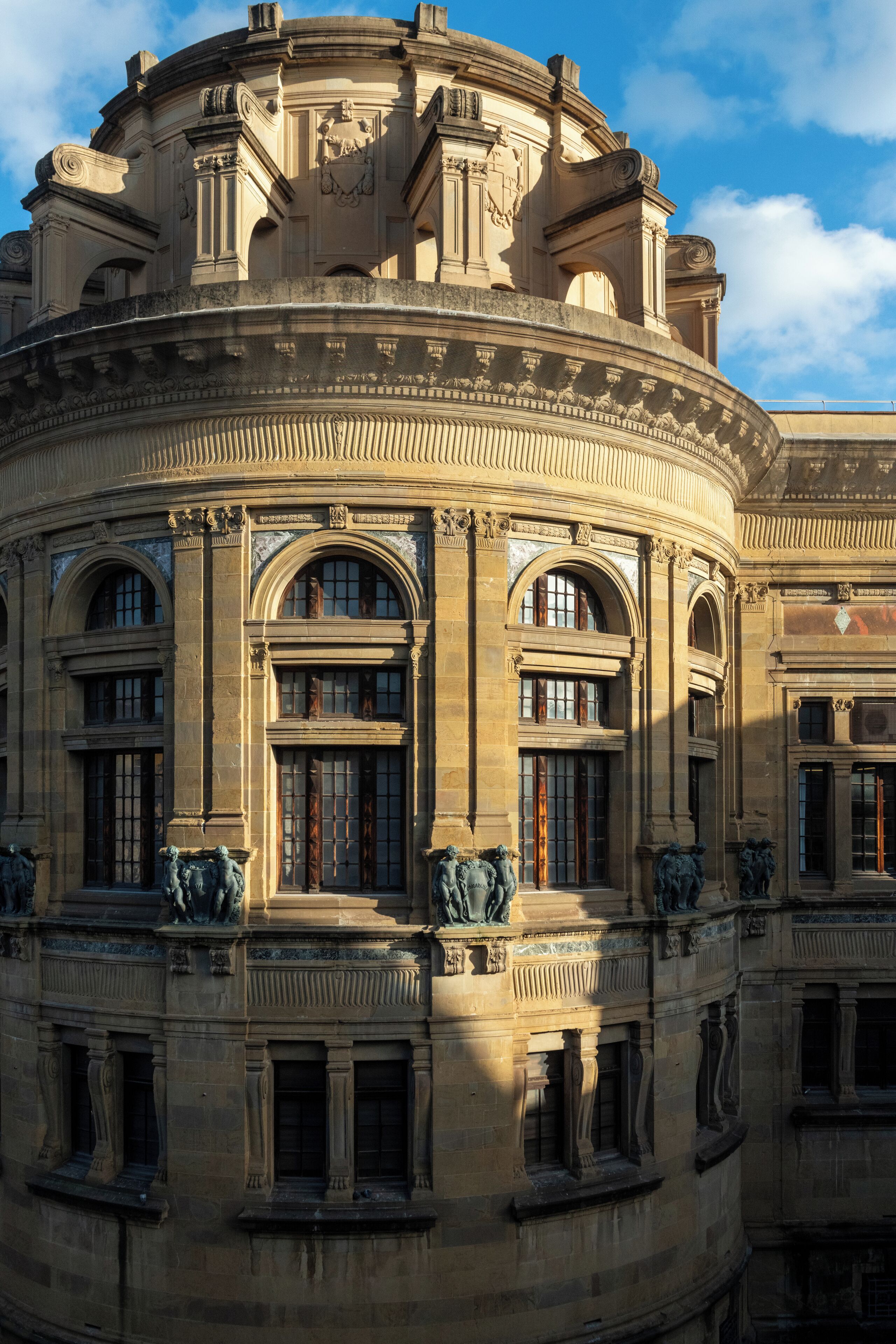 A historic building with classical architecture, featuring arched windows and detailed stonework.