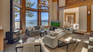 Un salón espacioso con ventanas amplias, chimenea y televisor.