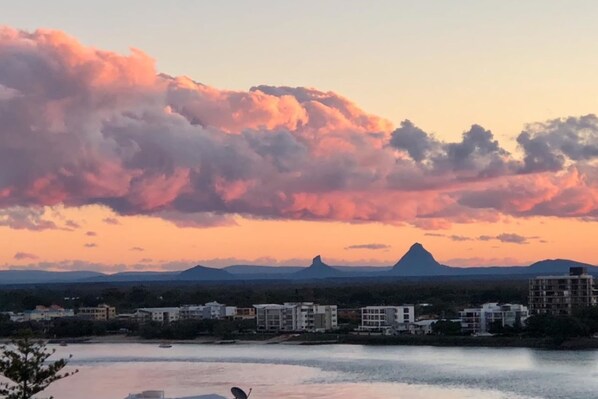 A coastal cityscape with buildings and a mountain in the background.