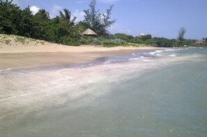 A beach with clear water, a sandy shore, and some vegetation. - family-run accommodation in the middle of BillysBay, only 2 minutes to the local beach (Treasure Beach)