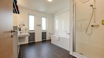 A modern bathroom with a glass shower enclosure, a bathtub, and a sink.