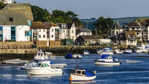 A harbor with boats docked, a stone wall, and buildings with traditional architecture. - Central Spacious Ground Floor Flat with Courtyard (Kingsbridge)