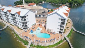 Un hotel con piscina, diversi balconi e vista sul lungomare.