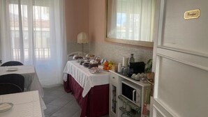 A breakfast setup with a table, a coffee machine, and a fruit bowl. - La Terrazza su Palermo : Camera Matrimoniale Deluxe con Vasca (Palermo)