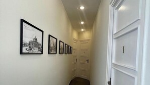 A hallway with framed pictures on the wall, a door labeled '1', and a door labeled '2'. - La Terrazza su Palermo : Camera Matrimoniale Deluxe con Vasca (Palermo)