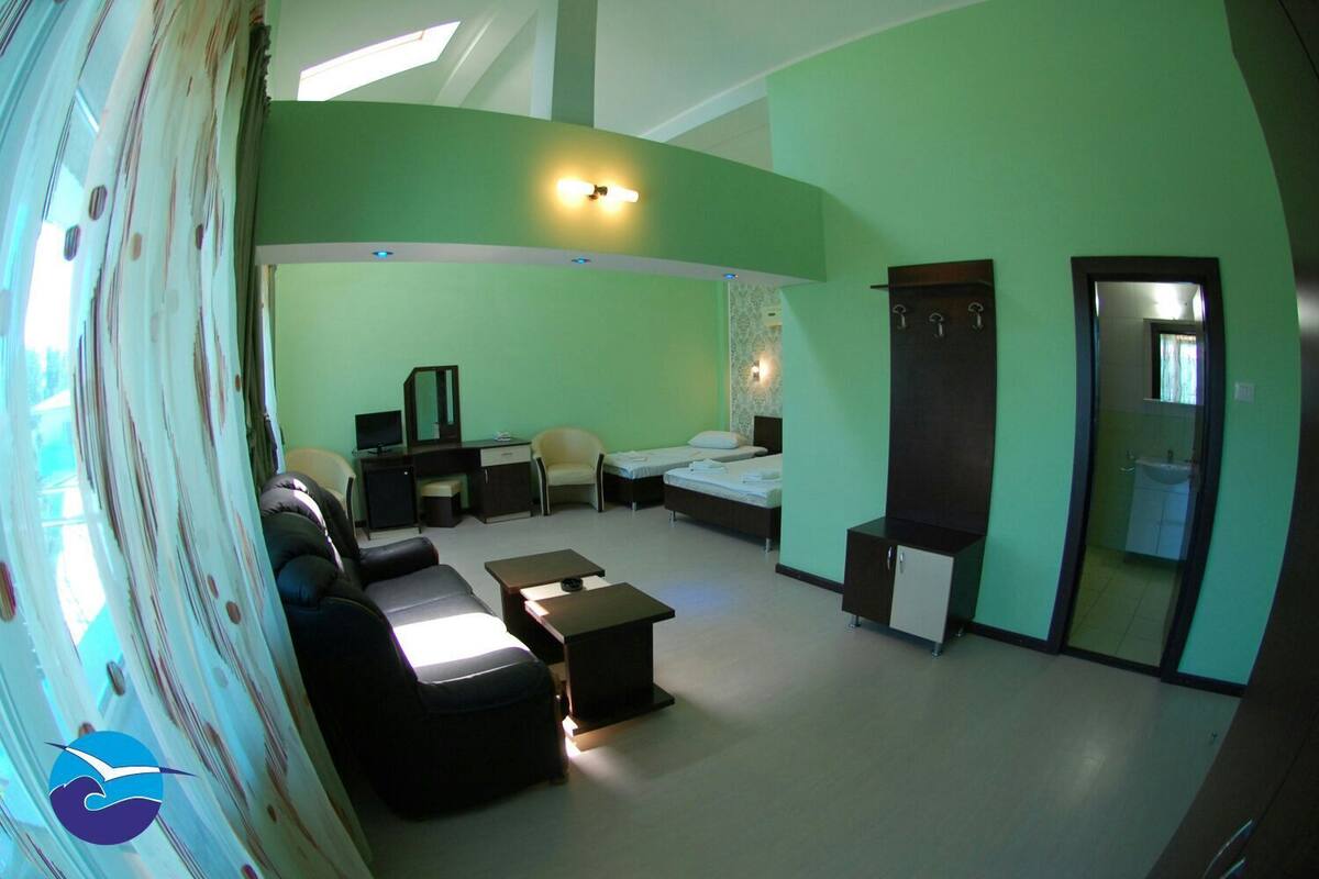 A room with a sofa, a desk, a bed, and a wardrobe.