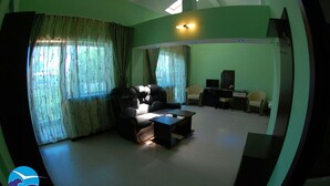 A living room with a sofa, a coffee table, a TV, and a desk. - Vila Alessia (Eforie)