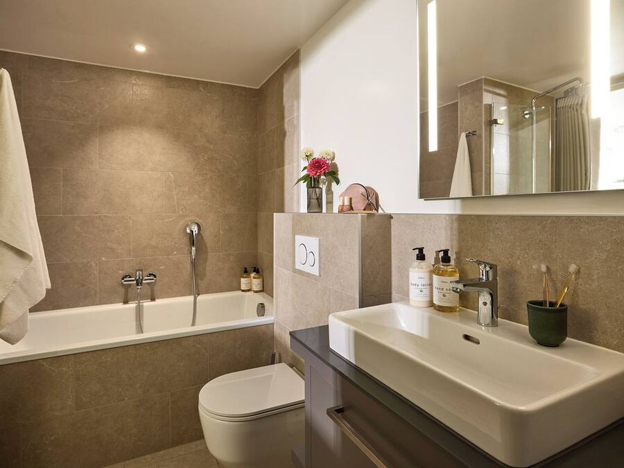 A modern bathroom with a bathtub, a toilet, and a vanity with a sink.
