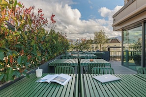 Guests can enjoy a tranquil outdoor seating area surrounded by lush greenery.