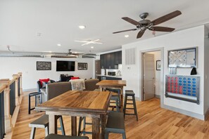 A modern kitchen with dark cabinets, a microwave, and a coffee machine. - Majestic Lofts #601 - Penthouse (Nashville)