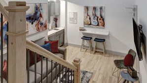 Un interior moderno con una escalera, un área de comedor y una zona de estar.