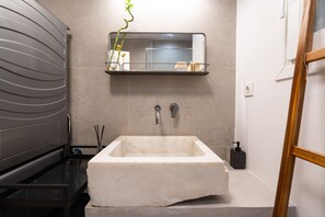 A bathroom with a large, rectangular sink, a mirror above it, and a small shelf with a plant. - 2BR Greek Home | Private Backyard 20' to Acropolis (Athens)