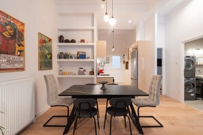 A modern kitchen with a dining table, chairs, and a built-in oven. - 2BR Greek Home | Private Backyard 20' to Acropolis (Athens)
