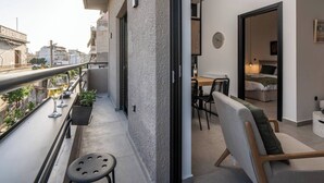 A balcony with a table, chairs, and potted plants. - 2BR Suite Apt • Acropolis Rooftop Views • By Metro (Athens)
